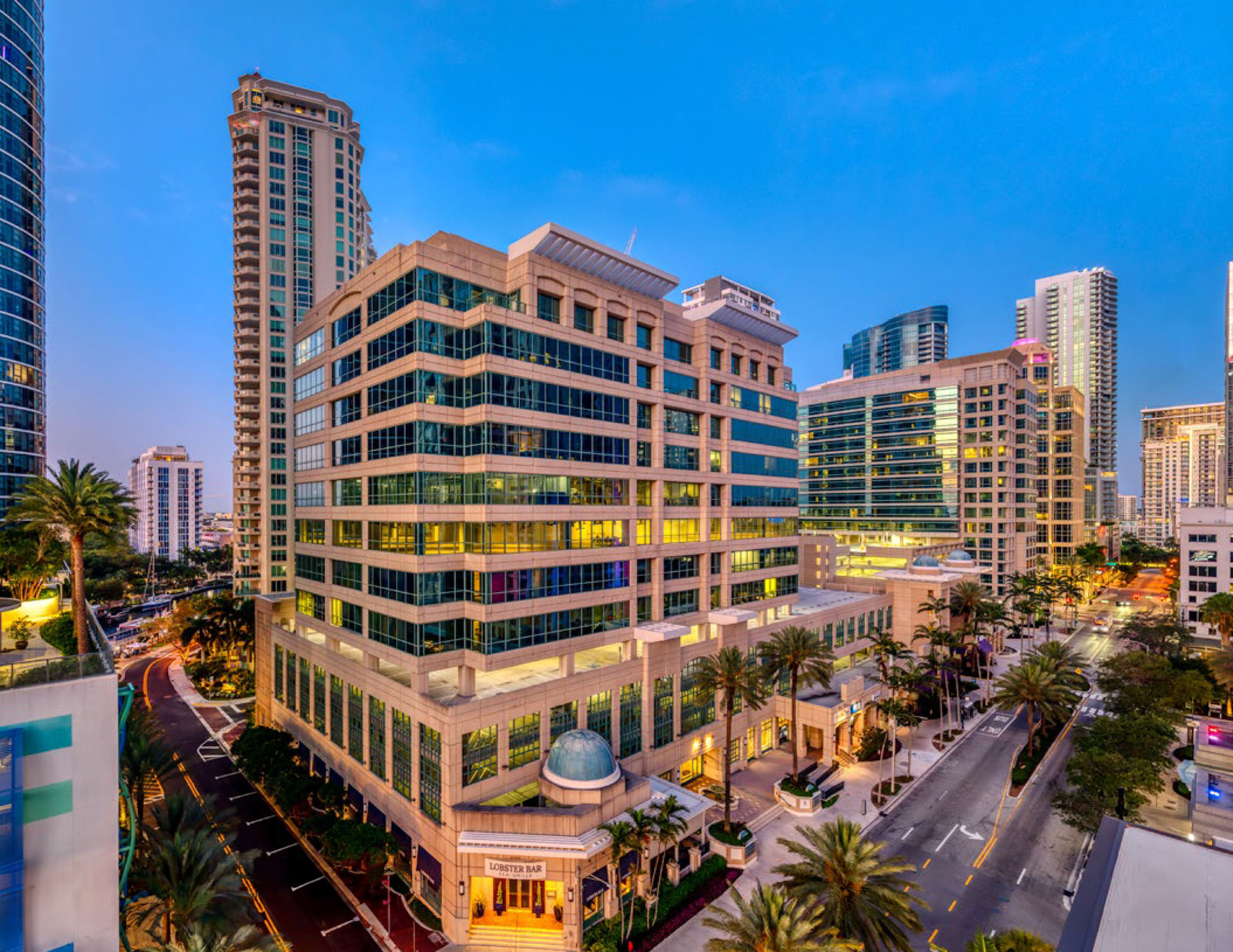 Twilight view of downtown Fort Lauderdale from above East Las Olas Boulevard, with palm-lined streets and high-rise towers